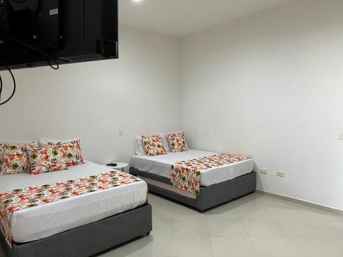 a room with two beds and a flat screen tv at Casa Campestre Veracruz in Pereira