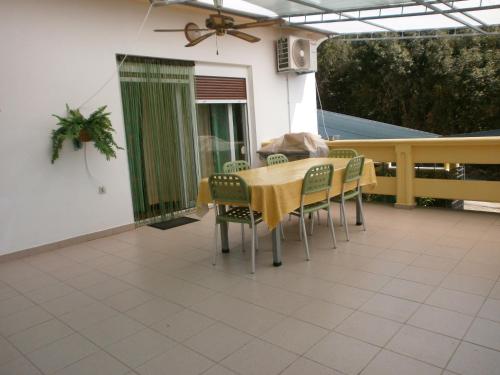 a dining table and chairs on a patio at Apartments by the sea Guduce, Ugljan - 13274 in Ugljan