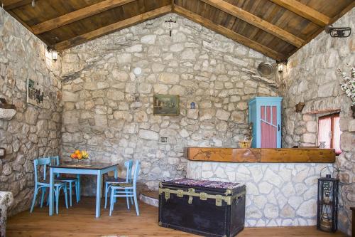 a room with a table and chairs and a stone wall at Secluded house with a parking space Tomislavovac, Peljesac - 13280 in Putniković