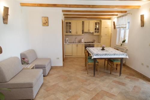a kitchen and living room with a table and a couch at Apartments with a parking space Zagore, Opatija - 13277 in Mošćenička Draga