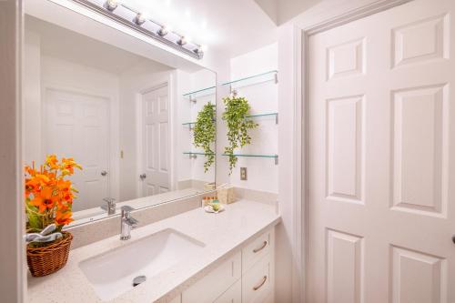 a bathroom with a sink and a mirror at Beautiful Ocean and Diamond Head Views with Parking in Honolulu