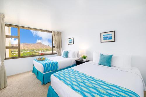 a hotel room with two beds and a large window at Beautiful Ocean and Diamond Head Views with Parking in Honolulu