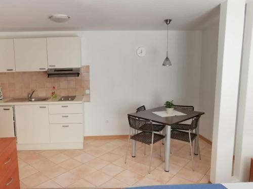 eine Küche mit einem Tisch und Stühlen im Zimmer in der Unterkunft Apartments by the sea Cres - 13312 in Cres