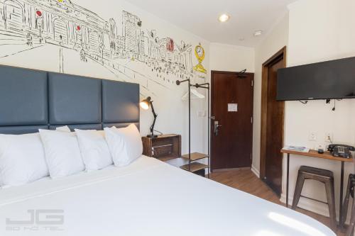 a bedroom with a large white bed with white pillows at JG Sohotel in New York