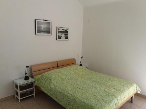 a bedroom with a bed and two pictures on the wall at Apartments by the sea Brgulje, Molat - 13318 in Molat