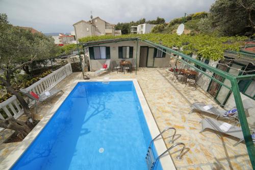 a swimming pool in front of a house at Family friendly apartments with a swimming pool Bol, Brac - 13364 in Bol