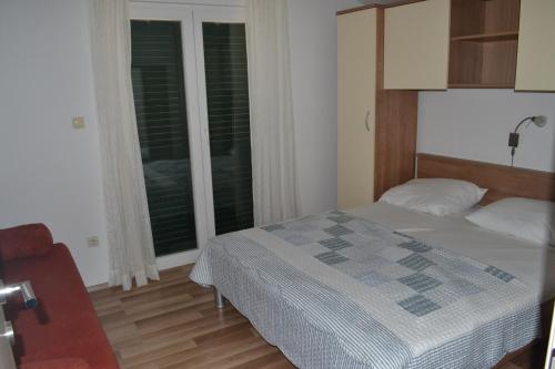 um quarto com uma cama e uma grande janela em Apartments with a parking space Grebastica, Sibenik - 13365 em Bašelovići