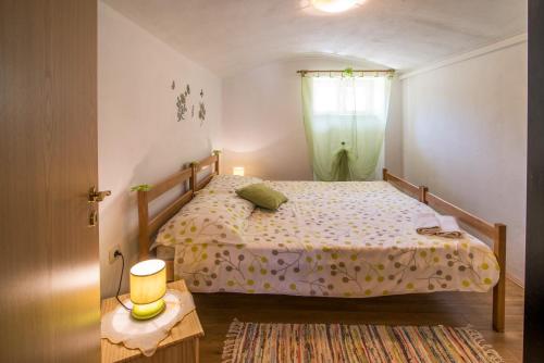 a small bedroom with a bed and a window at Apartments with a parking space Malinska (Krk) - 13219 in Malinska