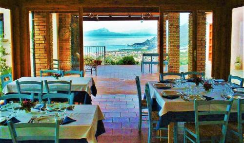 comedor con mesas y sillas y vistas en Agriturismo Nappi - Azienda Agricola Piano delle Vigne, en Praia a Mare