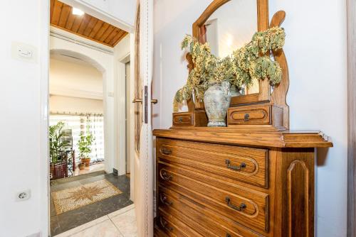 - une commode en bois avec un miroir et un vase dans l'établissement Luxury villa with a swimming pool Rogoznica - 13374, à Rogoznica