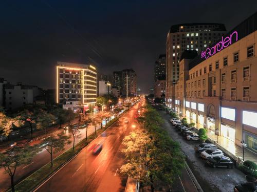 a city street at night with cars parked at Reyna Hotel Hanoi & Spa in Hanoi
