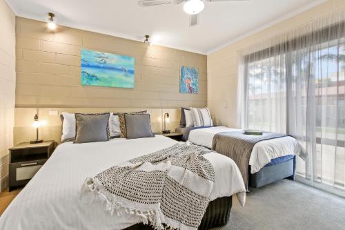 een slaapkamer met 2 bedden en een raam bij Sandbar Motel in Lakes Entrance