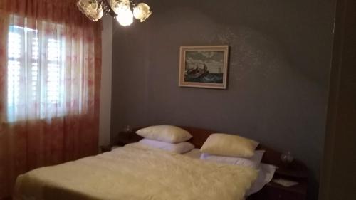Un dormitorio con una cama con almohadas. en Apartments with a parking space Klis, Split - 13435, en Klis