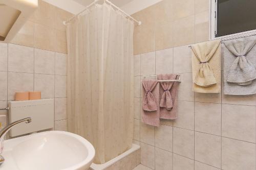 a bathroom with a shower curtain and a sink at Apartments with a parking space Brela, Makarska - 11687 in Brela