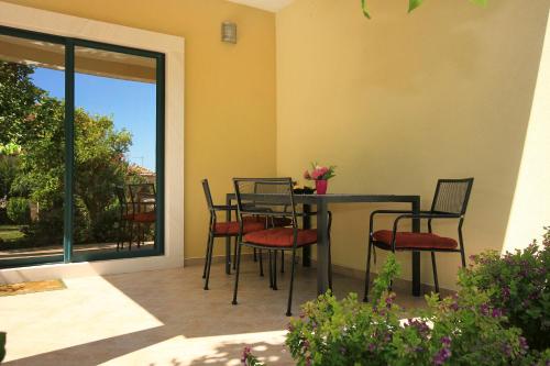 a patio with a table and chairs and a window at Apartments with a parking space Orebic, Peljesac - 10097 in Orebić