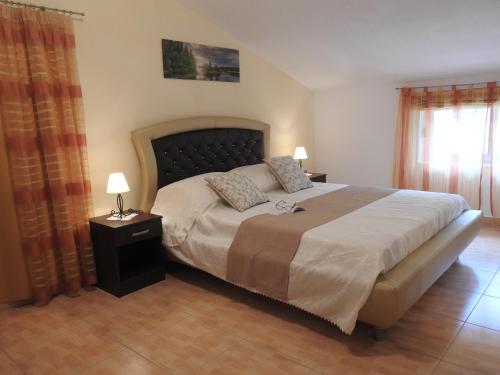 a bedroom with a bed and two lamps and a window at Apartments by the sea Brna, Korcula - 13492 in Smokvica