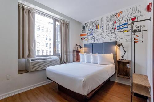 - une chambre avec un grand lit et une fenêtre dans l'établissement JG Sohotel, à New York