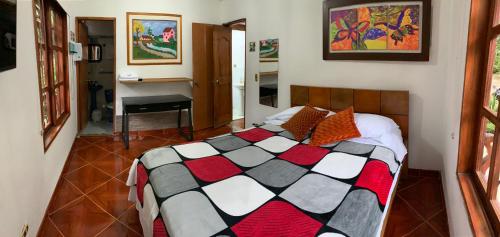 a bedroom with a bed with a checkered blanket at Casa Huespedes EL ENSUEÑO in Jardin