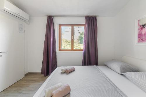 un dormitorio con una cama con dos animales de peluche en Apartments and rooms by the sea Sumartin, Brac - 13285 en Sumartin