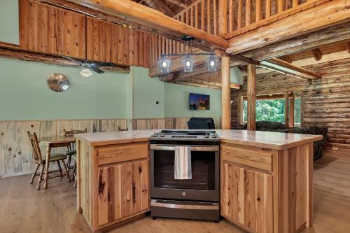 a kitchen with wooden cabinets and a stove in a cabin at Blue Moon Resort & Motel in Hill City