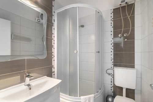 y baño blanco con lavabo y ducha. en Apartments and rooms by the sea Sumartin, Brac - 13285 en Sumartin