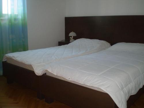 a bedroom with a large bed with white sheets at Apartments by the sea Bol, Brac - 13539 in Bol