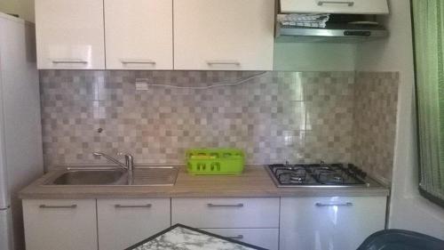 eine kleine Küche mit Spüle und Herd in der Unterkunft Seaside holiday house Zatoglav, Rogoznica - 13540 in Rogoznica