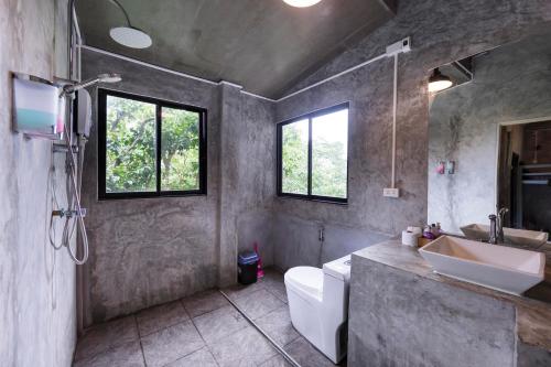a bathroom with a sink and a toilet and window at Deishaview Jungle Hostel in Koh Tao