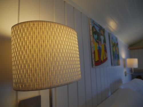 a yellow lamp in a room with a bed at La Joupa case Anthurium in Sainte-Rose