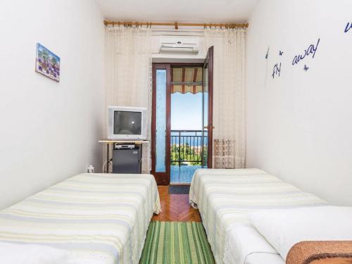 two beds in a room with a television at Apartments with a parking space Kastav, Opatija - 13568 in Kastav