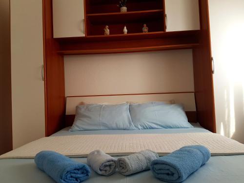 a bed with two pillows and towels on it at Apartment Nin 13571a in Nin