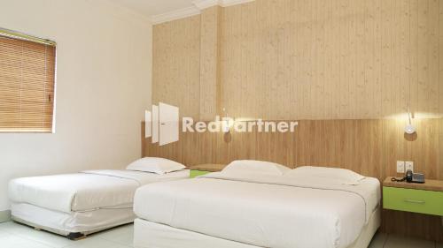 A bed or beds in a room at Wisma Sederhana Mitra RedDoorz