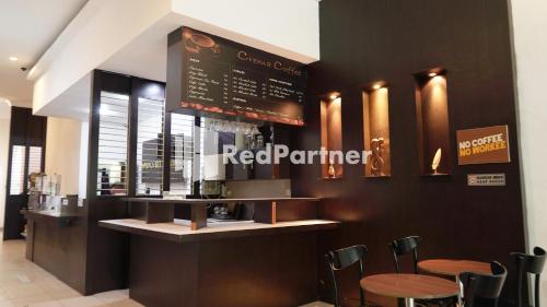 a restaurant with a bar with stools and a menu at Wisma Sederhana Mitra RedDoorz in Medan