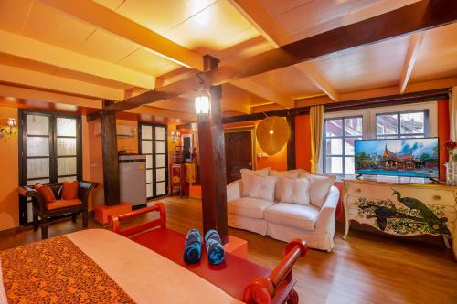 a living room with a white couch and a table at Royal Thai Villa Phuket - SHA Extra Plus in Rawai Beach
