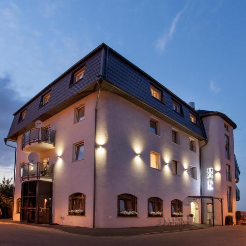 a large white building with a black roof at Amber Hotel in Gdańsk