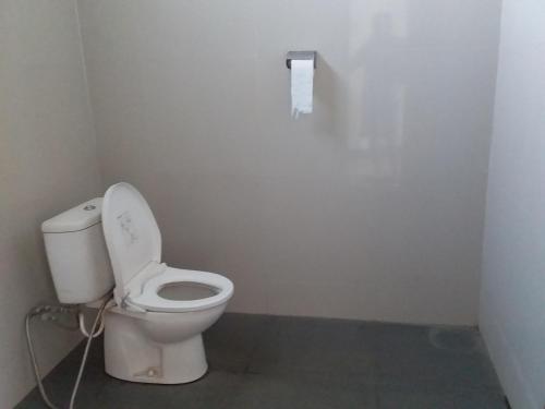 a bathroom with a toilet and a roll of toilet paper at SHILA GUEST HOUSE in Kelimutu