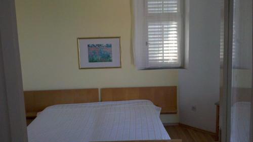 a small bedroom with a bed and a window at Apartments by the sea Brna, Korcula - 13618 in Smokvica