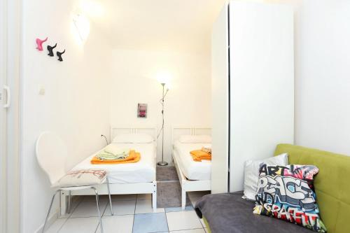 Cette petite chambre comprend deux lits et un canapé. dans l'établissement Apartments with WiFi Split - 13659, à Split