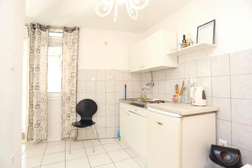 - une petite cuisine blanche avec une chaise noire dans l'établissement Apartments with WiFi Split - 13659, à Split