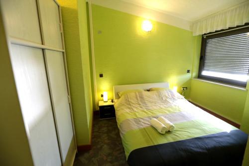 a green room with a bed with two towels on it at Apartments and rooms by the sea Pirovac, Sibenik - 13654 in Pirovac