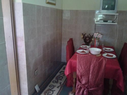 een tafel met een rode tafeldoek en borden erop bij Apartments with a parking space Primosten - 13671 in Primošten
