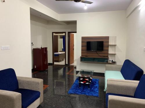 a living room with two couches and a tv at Haven Homes in Yelahanka