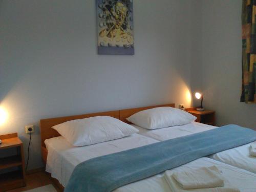 1 Schlafzimmer mit 2 Betten mit weißer Bettwäsche und einer blauen Decke in der Unterkunft Apartments by the sea Prapratno (Peljesac) - 13500 in Ston