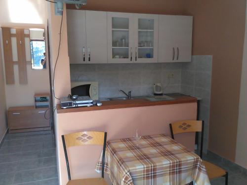 eine Küche mit einem Tisch, Stühlen und einem Waschbecken in der Unterkunft Apartments by the sea Prapratno (Peljesac) - 13500 in Ston