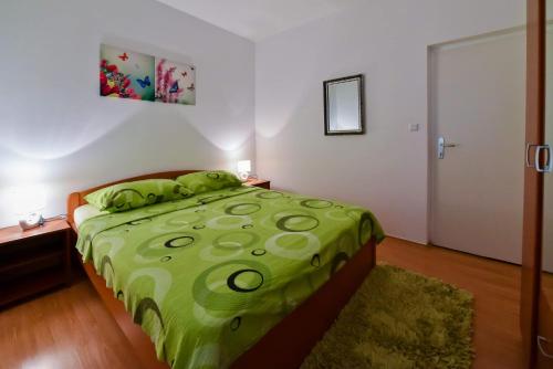 ラザナッツにあるSeaside holiday house Razanac, Zadar - 13677のベッドルーム1室(ベッド1台、緑の掛け布団付)