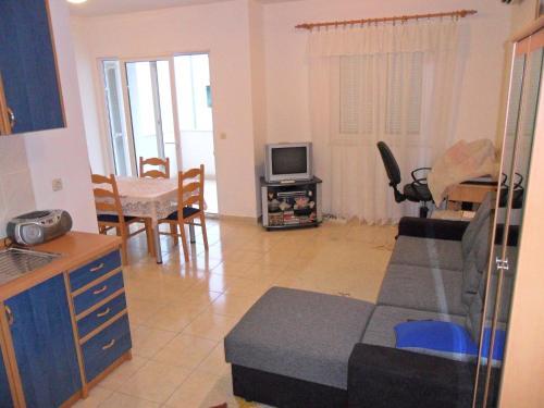 a living room with a couch and a tv in it at Apartments with a parking space Rogoznica - 13684 in Rogoznica