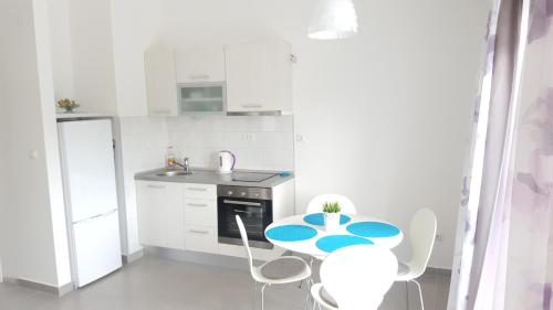 a small white kitchen with a table and chairs at Apartments by the sea Stomorska, Solta - 13695 in Stomorska