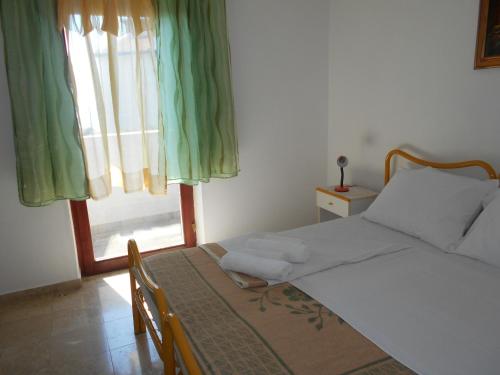 a bedroom with a bed and a window with green curtains at Quadruple Room Rovinj 13591i in Rovinj