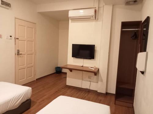 a room with a bedroom with a tv and a desk at I Harmony Hotel in Johor Bahru