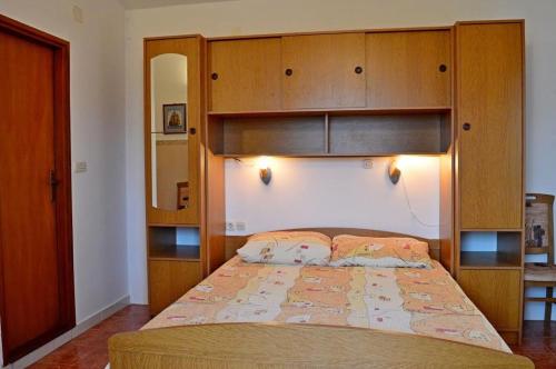 a bedroom with a large bed with a wooden headboard at Apartments by the sea Pag - 13251 in Pag